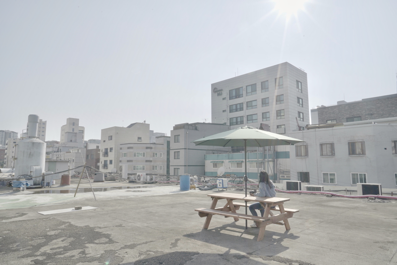 테이블과 파라솔이 설치된 오피스아트 건물 옥상 휴식 공간